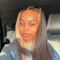 Black woman with dark roots, blonde wig, long, straight hair sitting inside a vehicle

